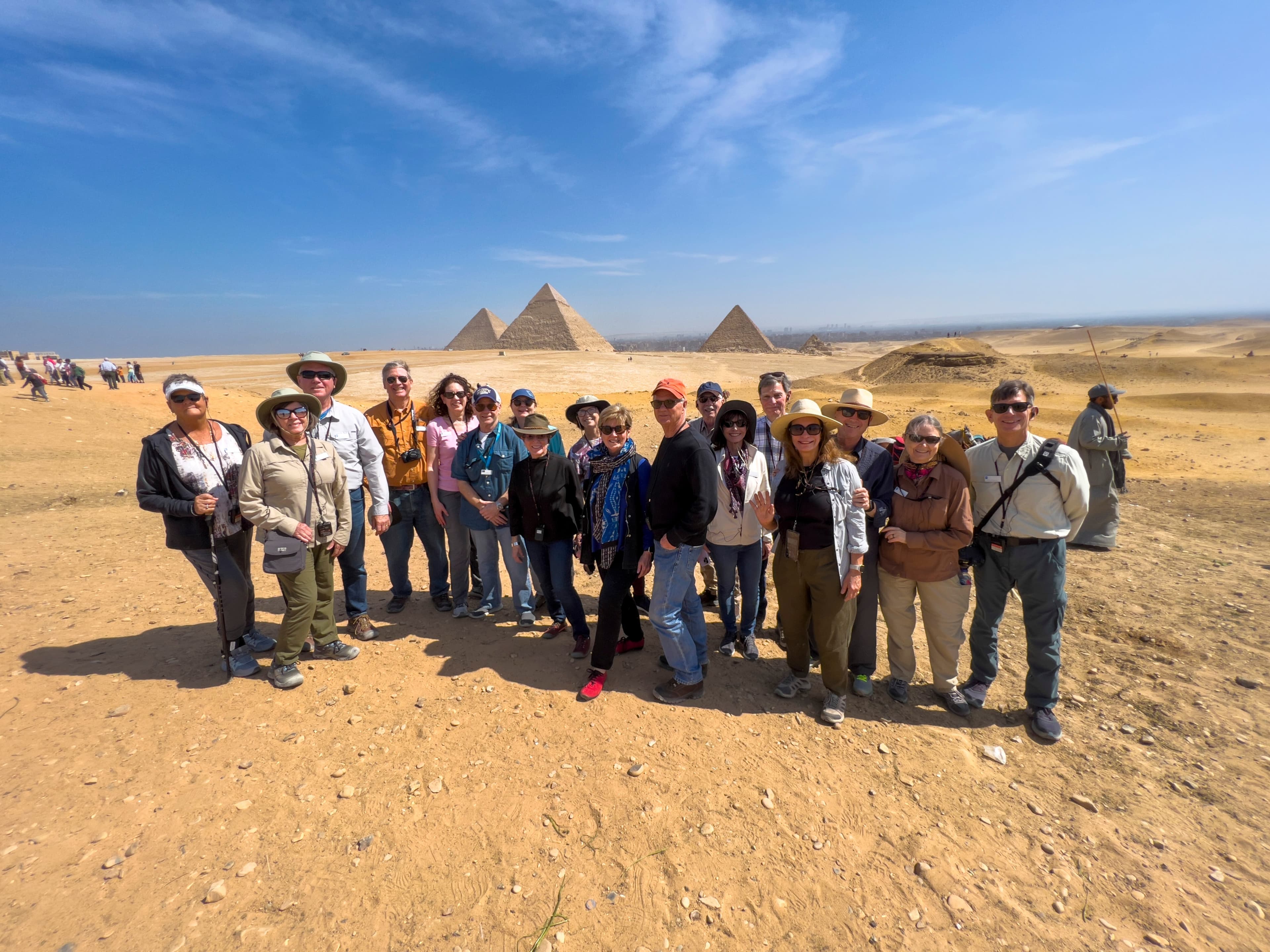 A group of guests pose for a photo in front of the Pyramids of Giza.