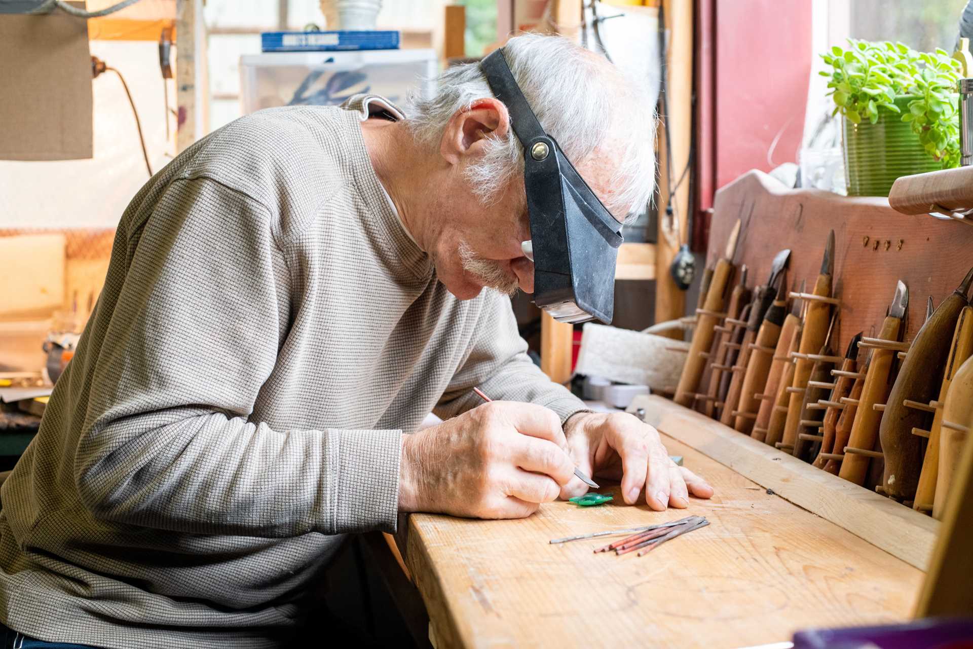 Artist Lou Cacioppo carves a piece of jewelry.