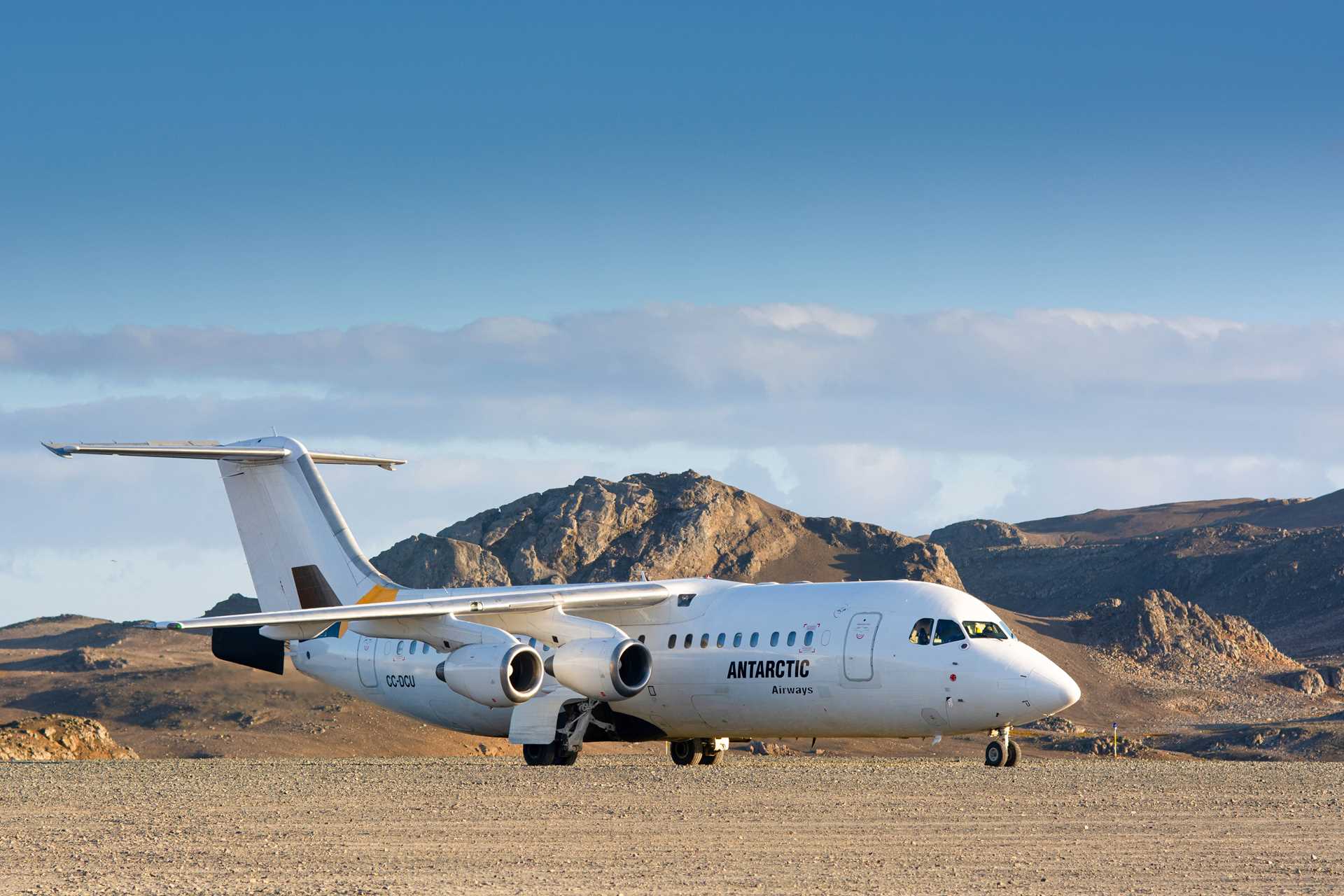 A medium-sized plane sits on the runway in Antarctica.